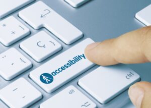 A person presses a button on their computer. They are pressing a key that is titled "Accessibility"